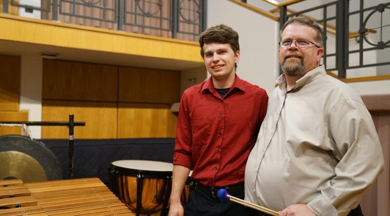 大卫•沃克, left, is director of percussion studies at 最靠谱的网赌软件. 在这里, he poses on stage at Chandler Recital Hall with his 儿子 Michael, 他是一名打击乐手，也是ODU的学生.