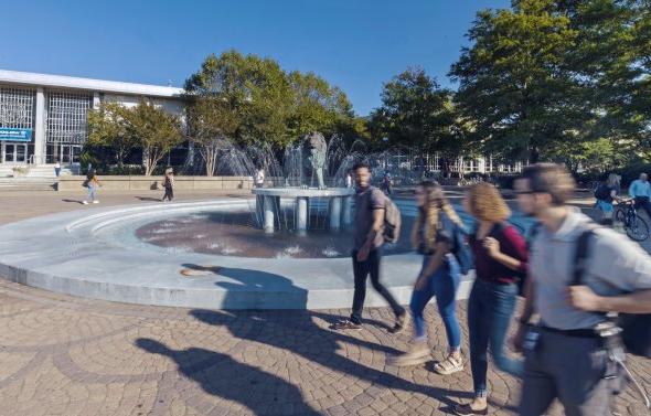 Students walking in front of fountain